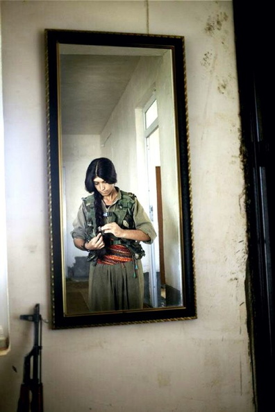 a Kurdish Woman Fighter makes her hair before she fights against ISIS.jpg