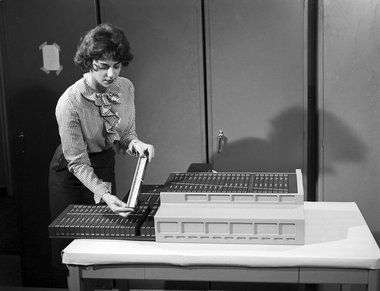A technician assembling the micrologic and core memory panels that make up the Apollo Guidance Computer into their housing.jpg