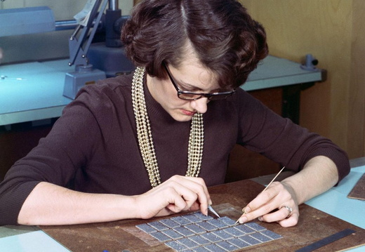 An unknown woman stringing the wiring components of the Apollo Guidance Computer memory.